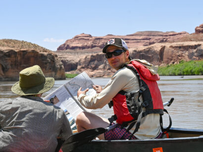 Gap Semester student reading a map while canoeing.