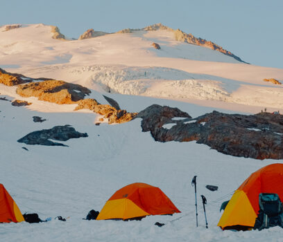 Three orange tents on Mt. Baker.