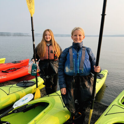 Two middle school girls with sea kayak paddles on Yellowstone Lake in Wyoming.