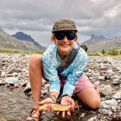 A young boy holding a trout he caught while fishing in the Pinnacles.