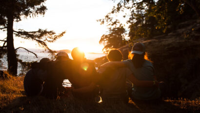 5 middle school students sitting and watching the sunset in the Puget Sound together.