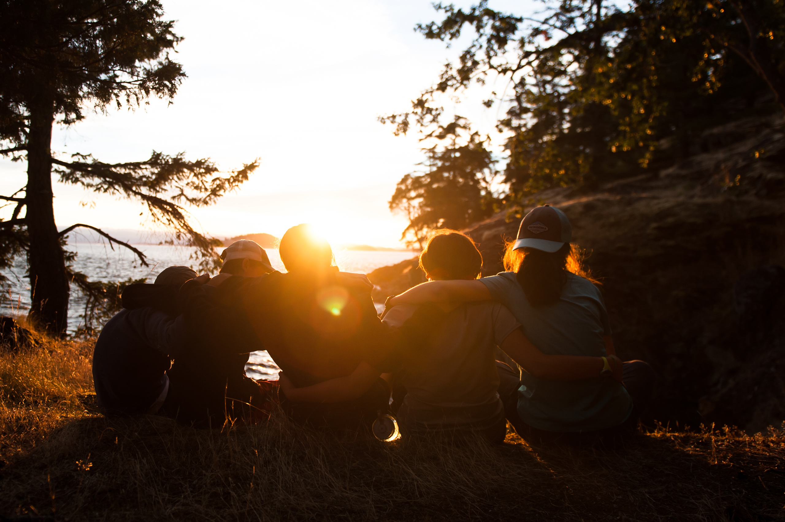 5 middle school students sitting and watching the sunset in the Puget Sound together.