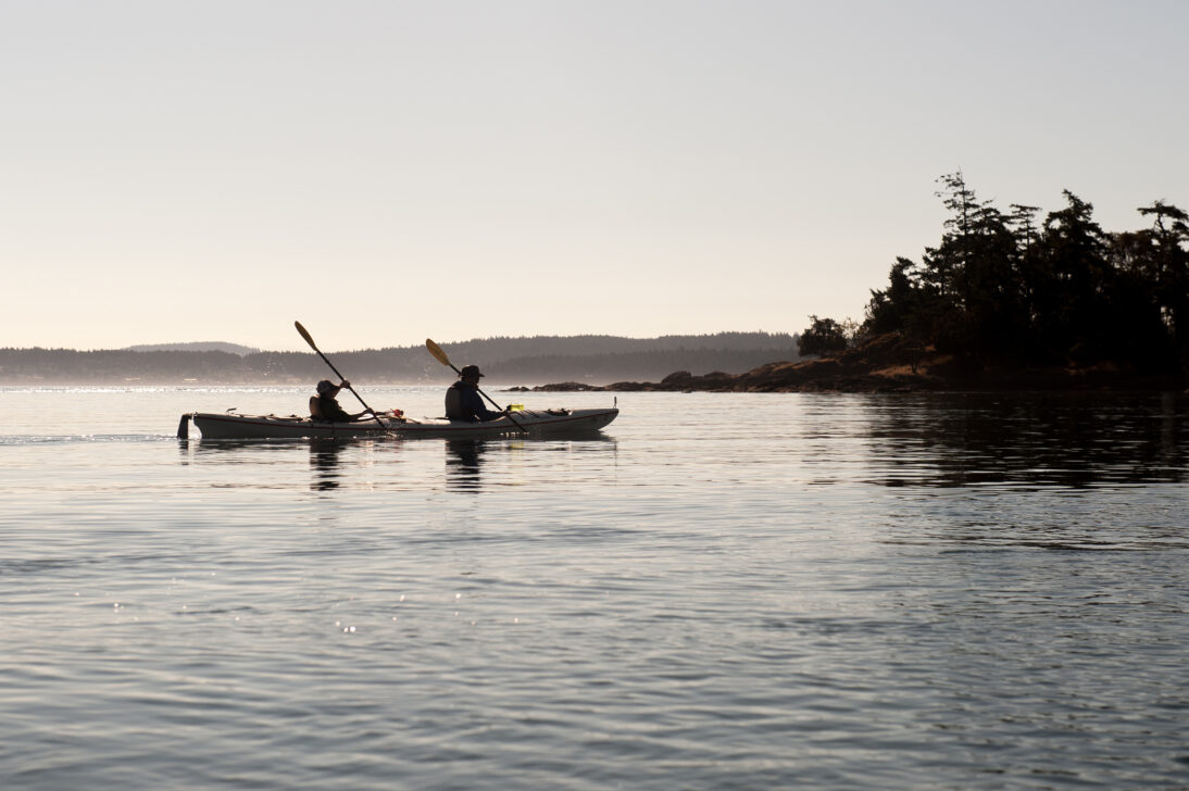 The silhouette of of kayakers in the San Juan Islands.
