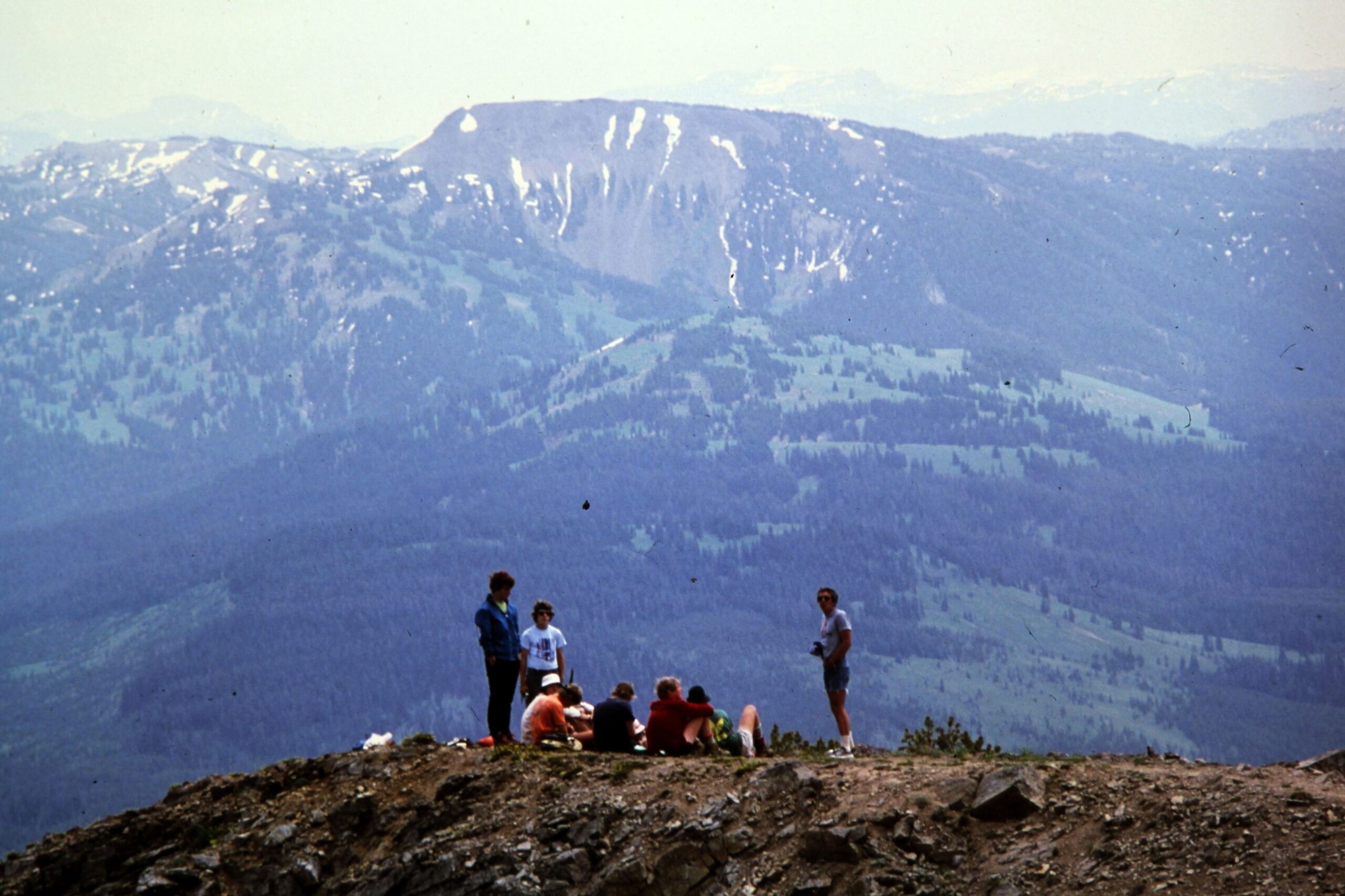 A group of teens in the 1980s standing on a mountain ridge. 
